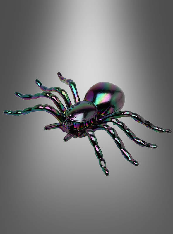 Eine schillernde Deko-Spinne (17 cm) mit gewellten Beinen glänzt vor einem grau verlaufenden Hintergrund – perfekt als auffälliger Halloween-Akzent für Ihre Halloween-Tischdekoration.