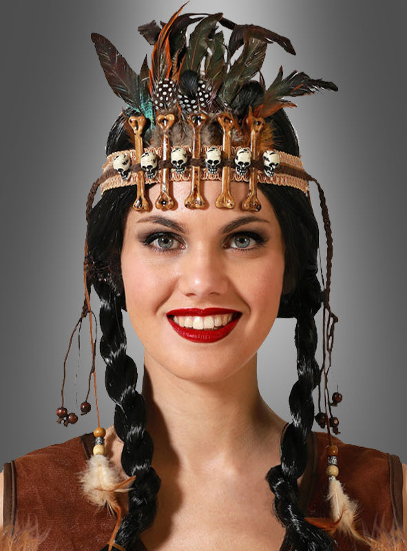 Vor einem grauen Hintergrund lächelt eine Frau mit geflochtenen Haaren und trägt dabei den auffälligen Kopfschmuck „Feder Haarschmuck mit Knochen“ – ein einzigartiges Accessoire zum Steinzeit-Kostüm, das mit Federn, Kunstknochen und Perlen verziert ist.