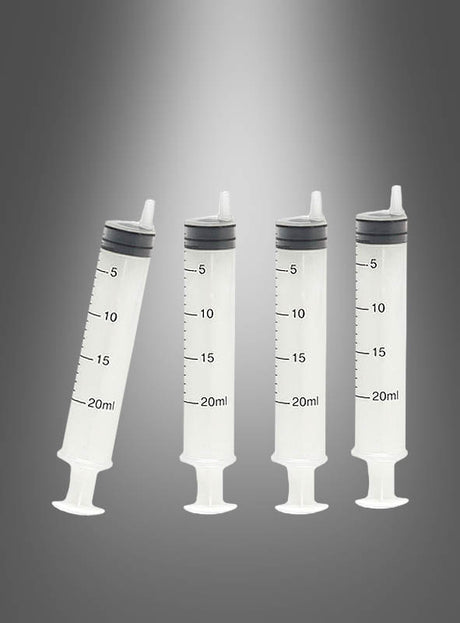 Vier leere 20-ml-Kunststoffspritzen aus dem Set „4 Spritzen für Kostüme 20 ml“ stehen aufrecht vor einem grauen Hintergrund mit Farbverlauf – ideal als Spritzen für Kostüme oder als Zubehör für Arztkostüme für Ihre nächste Mottoparty oder Halloween-Veranstaltung.