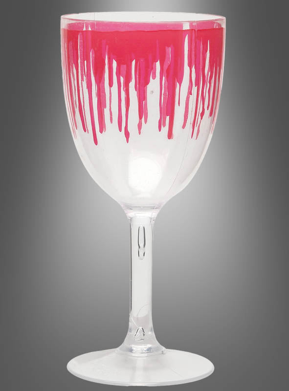 Das „Blutiges Weinglas Halloween 18 cm“ ist ein durchsichtiges Kunststoff-Weinglas, bei dem leuchtend rote Farbe vom Rand über den Kelch hinunterläuft und so eine blutige Optik erzeugt – ideal als gruseliges Trinkglas für Ihre Halloween-Party, hier abgebildet vor einem neutralen grauen Hintergrund.