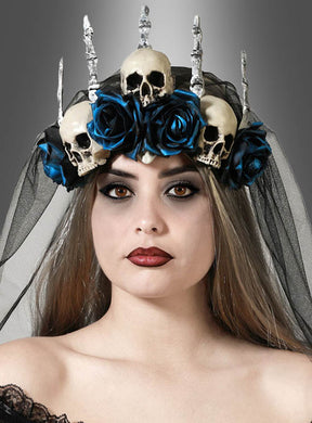 Eine Frau, die die „Halloween-Krone mit Schleier und blauen Rosen“ trägt – mit einem schwarzen Schleier, blauen Rosen, drei Totenköpfen und silbernen Stacheln –, steht vor einem neutralen Hintergrund.