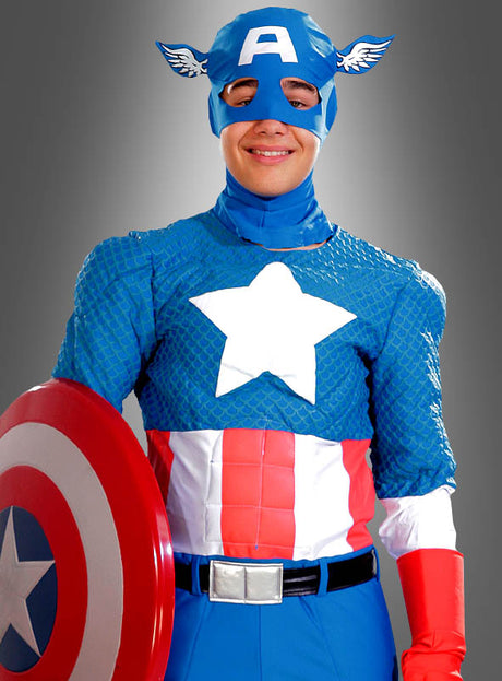 Eine Person, die das Captain-America-Kostüm Deluxe 2. Wahl trägt – mit einer blauen Maske, einem Stern-Emblem auf der Brust und einem rot-weiß-blauen Schild in der Hand –, steht vor einem grauen Hintergrund. Dieses offiziell lizenzierte Marvel-Kostüm ist ideal für alle Fans von Superhelden-Kostümen.