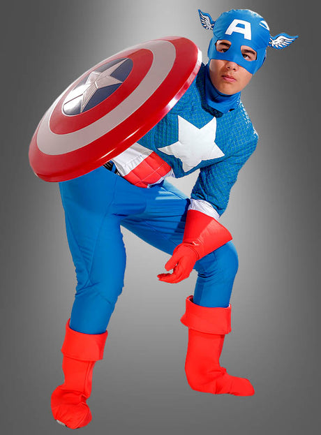Eine Person, die das Captain-America-Kostüm Deluxe 2. Wahl trägt – komplett mit Schild, roten Handschuhen und Stiefeln –, posiert vor einem grauen Hintergrund mit Farbverlauf – ideal für Fans, die ein authentisches Marvel-Lizenzkostüm oder ein klassisches Superhelden-Kostüm suchen.