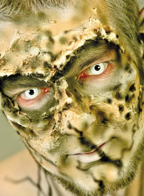 Eine Person mit Spezialeffekt-Make-up, das verbrannte, vernarbte Haut nachahmt, und mit „Jahreslinsen White Zombie weiß“ – einer auffälligen Art von Effektkontaktlinsen – starrt in die Kamera.