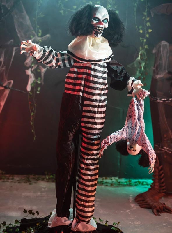 Erleben Sie gruseligen Halloween-Nervenkitzel mit dem „Animierten Clown mit Kind 170 cm Deko mit Bewegungsmelder“ – einem lebensgroßen Clown mit unheimlichem Gesichtsausdruck in einem gestreiften Outfit, der eine auf den Kopf gestellte Puppe umklammert. Umgeben von unheimlichem Kunstlaub und durch einen Bewegungssensor aktiviert, sorgt diese böse Clown-Dekoration für unvergessliche, animierte Halloween-Dekorationen.