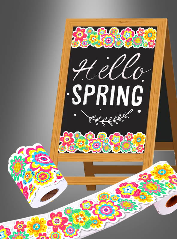 Auf einem Kreidetafelschild steht „Hello Spring“ mit bunten Blumenrändern, was die fröhliche Stimmung der „Sommerfest Hippie Party Deko Aufkleber Rolle 20 m“ widerspiegelt. Vor dem Schild liegen dekoratives Toilettenpapier mit passenden Blumenmustern und verspielte Aufkleber von der 20-Meter-Rolle.
