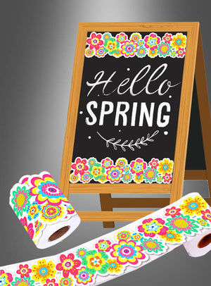 Auf einem Kreidetafelschild steht „Hello Spring“ mit bunten Blumenrändern, was die fröhliche Stimmung der „Sommerfest Hippie Party Deko Aufkleber Rolle 20 m“ widerspiegelt. Vor dem Schild liegen dekoratives Toilettenpapier mit passenden Blumenmustern und verspielte Aufkleber von der 20-Meter-Rolle.