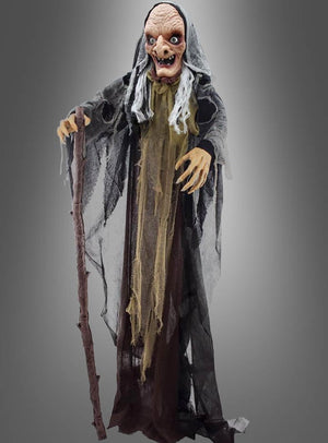 Die animatronische Hexenfigur „160 cm Halloween“ zeigt eine lebensgroße alte Hexe mit faltigem Gesicht, langen Fingern, zerfetzten Gewändern und einem Holzstab, die vor einem schlichten grauen Hintergrund steht – damit ist sie die perfekte Halloween-Dekoration für jede gruselige Kulisse.
