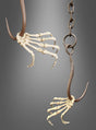 Zwei große Metallhaken sind in naturgetreue Skeletthände eingelassen, wodurch sich die „Lebensgroße Skeletthand am Haken mit Kette“ ideal für Ihre gruselige Dekoration eignet. Eine Hand ist an einer stabilen Aufhängekette befestigt, beide sind vor einem schlichten grauen Hintergrund angeordnet – perfekt als auffälliges Halloween-Dekorationselement.