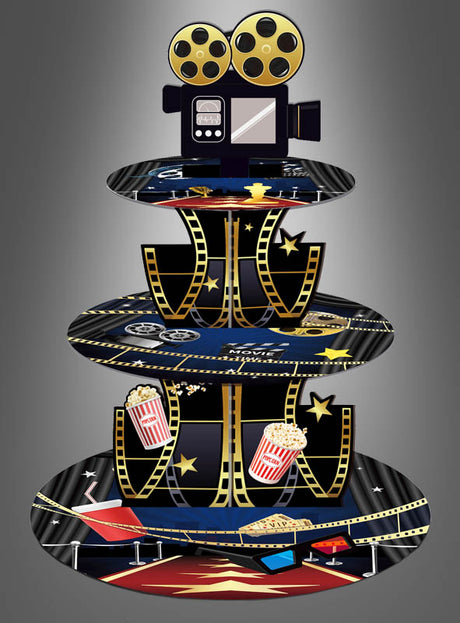 Ein dreistöckiger „Hollywood Kino Filmnacht“-Cupcake-Ständer, der wie Filmrollen gestaltet und mit Popcorn, Sternen und einer Filmkamera verziert ist, bildet vor einem grauen Hintergrund mit Farbverlauf die perfekte Tischdekoration für einen Filmabend.