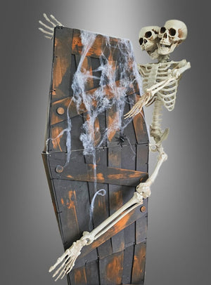 Aus dem „Rüttelnder Halloween-Sarg mit Ketten 160 cm“ – einem Holzsarg, der mit künstlichen Spinnweben, Ketten und einer Plastikspinne verziert ist und vor einem grauen Hintergrund steht – ragen zwei Skelette mit miteinander verwachsenen Oberkörpern und Köpfen hervor – eine beunruhigende Szene, die sich perfekt für jede gruselige Halloween-Dekoration eignet.