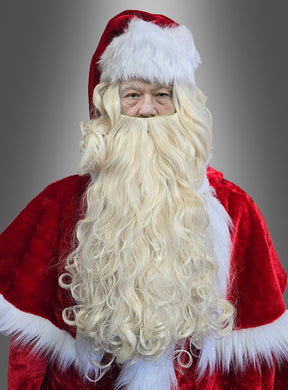 Hier ist Ihr umformulierter Satz unter Verwendung der angegebenen Produktdaten: Eine Person trägt ein rotes Weihnachtsmannkostüm und das „Luxus-Weihnachtsmann-Perücken- und Bart-Set, waschbar“ – einen langen, lockigen blonden Bart und eine Nikolausperücke – und steht vor einem grauen Hintergrund mit Farbverlauf.