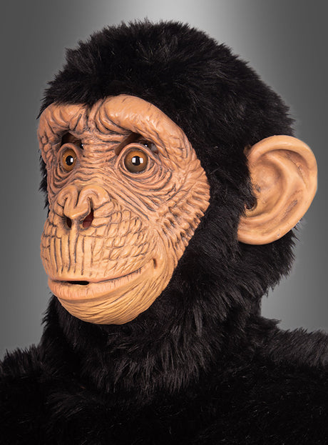 Eine Person, die eine „Realistische Affenmaske für Erwachsene“ mit detaillierten Gesichtszügen und schwarzem Fell trägt, vor einem grauen Hintergrund. Diese aus hochwertigem Latex gefertigte Maske sorgt bei jeder Kostümparty für einen authentischen Look.