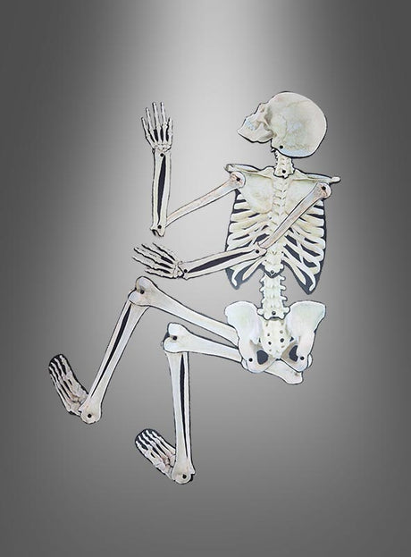Eine „Bewegliche Skelett-Wanddekoration 158 cm“ ist auf der Seite liegend dargestellt, mit erhobenen Armen und angewinkelten Knien vor einem grauen Hintergrund mit Farbverlauf – perfekt, um als Teil Ihrer Halloween-Dekoration eine gruselige Atmosphäre zu schaffen.