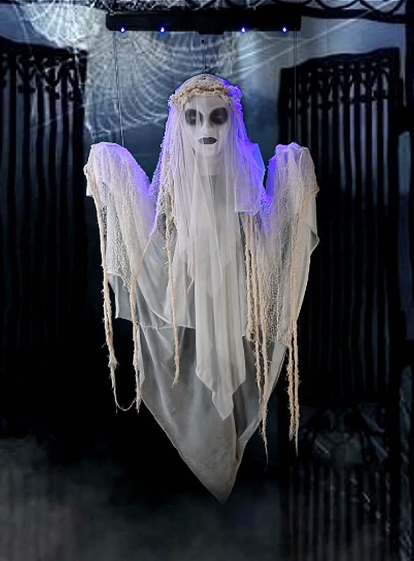 Die 120 cm große „Schwebende Geisterbraut“ ist eine beeindruckende Halloween-Dekoration: Sie hängt vor schwarzen Toren, trägt weiße, zerfetzte Gewänder sowie eine kronenähnliche Kopfbedeckung und hat hohle Augen, die von blauen Lichtern beleuchtet werden.