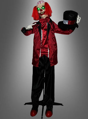 Eine Figur namens „Animierter Zombie-Clown 170 cm Halloween-Dekoration“ mit leuchtend grünen Augen, roten Haaren und einem rot-schwarzen Outfit hält einen schwarzen Zylinder vor einem grauen Hintergrund in der Hand.