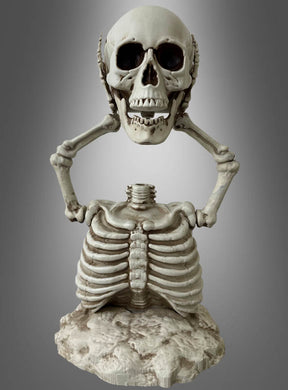 Das 40 cm große Skelett mit abgetrenntem Kopf wird auf einem Friedhof gezeigt, wobei der Kopf von beiden Armen über dem Brustkorb gehalten wird – die ideale Halloween-Dekoration für eine gruselig-schöne Atmosphäre vor einem schlichten Hintergrund.