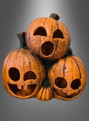 Drei geschnitzte Kürbisse mit unterschiedlichen Gesichtsausdrücken sind vor einem grauen Hintergrund mit Farbverlauf übereinander gestapelt – die bezaubernden „Kürbisgeister 29 cm mit LED“, perfekt als Halloween-Dekoration oder für alle, die auf der Suche nach einer Kürbisdekoration mit LED-Licht sind.