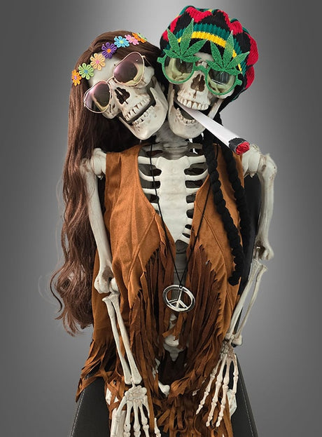 Zwei lebensgroße menschliche Skelettfiguren (153 cm) mit zwei Köpfen, beide als Hippies verkleidet – eine trägt eine Perücke und ein Blumenstirnband, die andere eine Mütze, eine Sonnenbrille und einen Spielzeug-Joint; beide in braunen Westen mit Peace-Kette – ideal als ausgefallene Halloween-Dekoration.