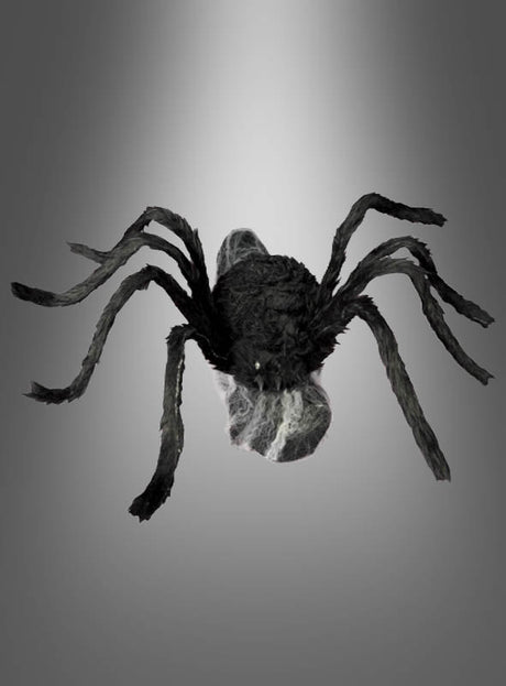 Eine springende Spinne (70 x 50 cm) in Schwarz mit acht Beinen und sichtbaren Fangzähnen wird vor einem grauen Farbverlauf präsentiert – ideal als Halloween-Dekoration oder für deine eigene Inszenierung mit einer animierten Riesenspinne.