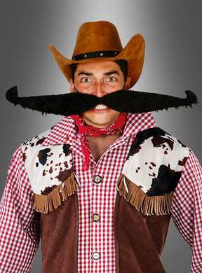 Eine Person in einem Cowboykostüm mit braunem Hut, rotem Halstuch, einer Weste mit Kuhfleckenmuster und einem riesigen, karikaturhaften Schnurrbart steht vor einem grauen Hintergrund mit Farbverlauf – perfekt für den Karneval.