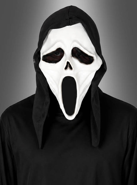 Eine Person, die die „Kapuzen Killer Maske“ aus PVC trägt – eine weiße Halloween-Maske mit übertrieben weit geöffnetem Mund und hohlen Augen –, kombiniert mit einem schwarzen Kapuzengewand, steht vor einem grauen Hintergrund.