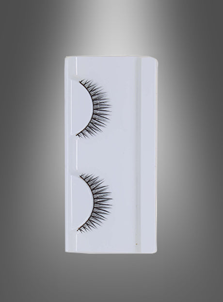 Ein Paar selbstklebende „Glamour“-Wimpern in einer weißen Kunststoffhülle, vertikal vor einem grau verlaufenden Hintergrund präsentiert. Diese selbstklebenden schwarzen Wimpern lassen sich mühelos anbringen und sorgen für einen ausdrucksstarken, glamourösen Look.