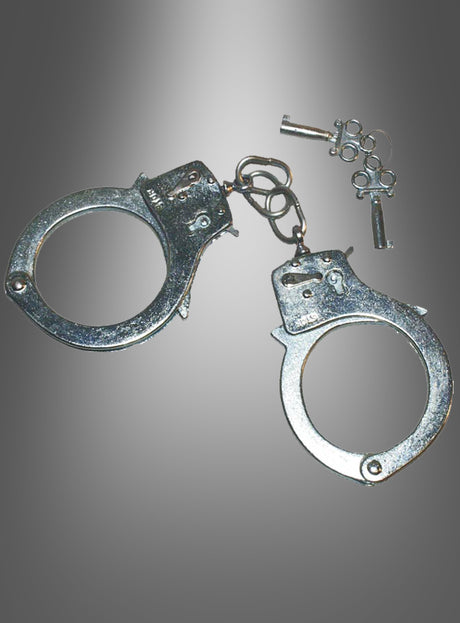 Ein Paar Handschellen aus Metall, komplett mit zwei kleinen Schlüsseln, wird vor einem grau verlaufenden Hintergrund gezeigt – damit ist dieses Produkt das perfekte Accessoire für den Karneval, um dein Polizeikostüm abzurunden.