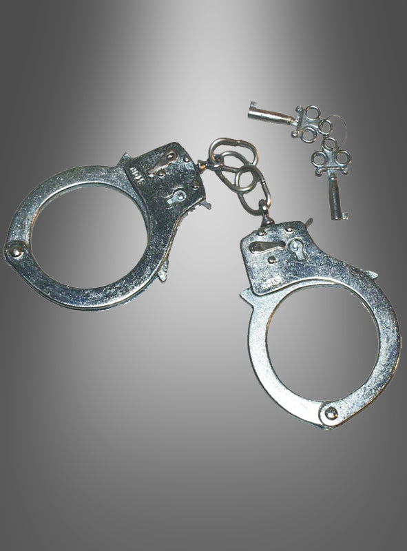 Ein Paar Handschellen aus Metall, komplett mit zwei kleinen Schlüsseln, wird vor einem grau verlaufenden Hintergrund gezeigt – damit ist dieses Produkt das perfekte Accessoire für den Karneval, um dein Polizeikostüm abzurunden.