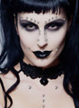 Eine Person mit Gothic-Make-up – schwarzer Lippenstift, auffälliger Lidschatten, ein schwarzes Spitzenhalsband und metallische Gesichtspiercings, die mit den „Fake Piercings zum Aufkleben, 30 Stück“ angebracht wurden – blickt direkt in die Kamera.