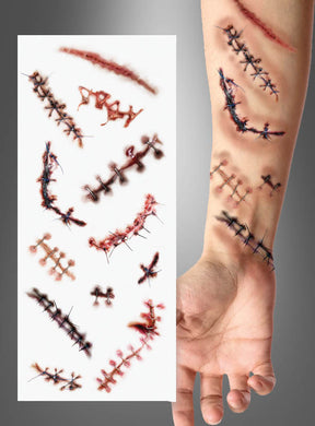 Ein menschlicher Unterarm zeigt mehrere Narben-Tattoos in Form von genähten Wunden, daneben liegt ein Blatt mit ähnlichen temporären Wunden-Tattoos – ein ideales Halloween-Kostüm-Accessoire, um deinen gruseligen Look zu vervollständigen.