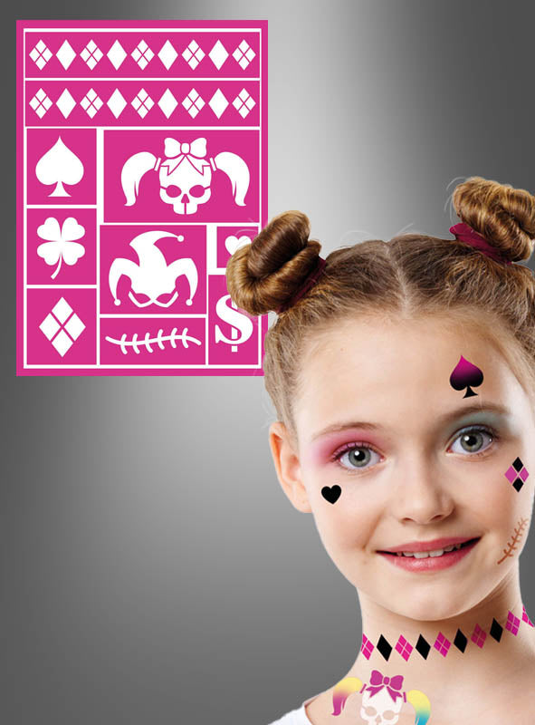 Ein lächelndes Mädchen mit Gesichtsbemalung in Form von Herzen, Pik-Symbolen und anderen Motiven; im Hintergrund ist eine rosa „Harlekin“-Schablone (14 × 20 cm) mit ähnlichen Motiven zu sehen.