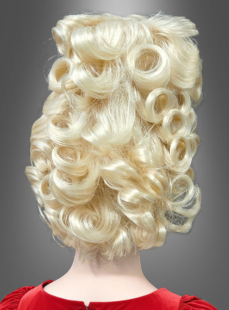 Eine Person mit platinblondem, stark gelocktem Haar, das zu einer übertriebenen, voluminösen „Premium Hochsteckfrisur Perücke Barock blond“ gestylt ist, und die ein rotes Kleidungsstück trägt, ist von hinten vor einem grauen Hintergrund zu sehen.