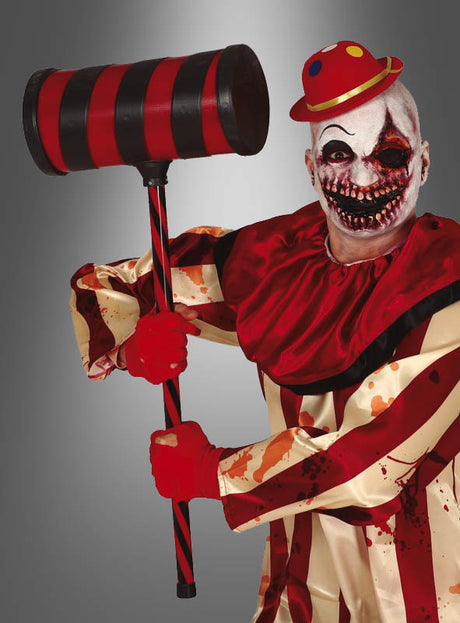 Eine Person in einem blutbefleckten Clownskostüm mit Gesichtsbemalung hält den „Gigantischen Clownhammer 80 cm Übergröße“ – das perfekte Halloween-Accessoire – in der Hand und trägt einen kleinen roten Hut vor einem grauen Hintergrund.