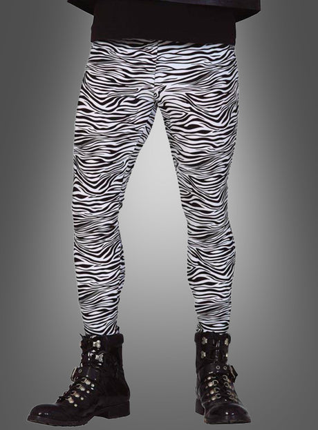 Ein Model präsentiert die „80er Zebra Hose Rocker Leggings“ in Kombination mit schwarzen Stiefeln und posiert vor einem schlichten grauen Hintergrund – ein markanter Look im Stil der 80er-Jahre-Rocker.