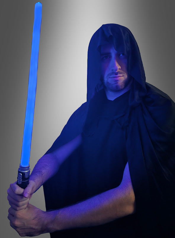 Eine Person in einem schwarzen Kapuzenmantel hält das „Leuchtendes Schwert für Kinder“ (65 cm), das blau leuchtet, vor einem grauen Hintergrund mit Farbverlauf.