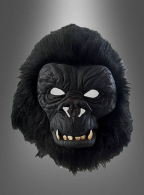Die „Realistische Gorilla-Vollmaske“ verfügt über schwarze, pelzartige Ränder, weiße Augenausschnitte und markante Zähne. Sie wurde fachmännisch aus strapazierfähigem Latex gefertigt und wird vor einem neutralen Hintergrund mit Farbverlauf präsentiert.