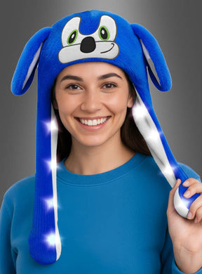 Eine Person, die einen blauen Pullover und die „Mütze blauer Igel mit bunten LEDs“ trägt – eine verspielte Plüsch-Igelmütze mit leuchtenden, bunten LED-Lichtern –, sorgt für einen fröhlichen und auffälligen Look.