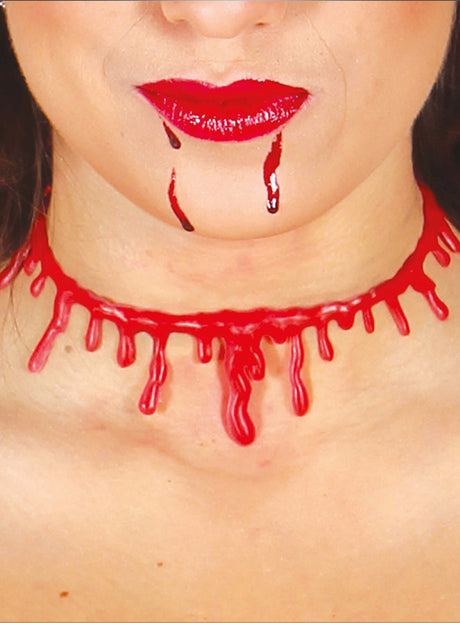 Eine Person mit glänzenden roten Lippen, aus deren Mund Kunstblut tropft und die eine Gurgelschnitt-Halskette um den Hals trägt – das perfekte Accessoire für ein Zombie-Kostüm zu Halloween.