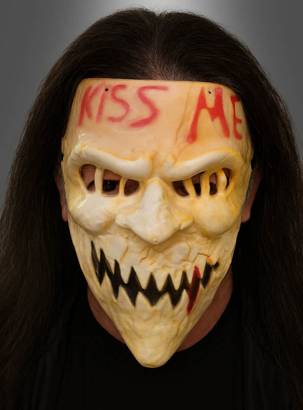 Wer die Halloween-Horror-Maske „Kiss Me“ für Herren trägt – eine gelbliche Totenkopfmaske mit scharfen Zähnen und einem auffälligen roten „KISS ME“-Schriftzug auf der Stirn –, hinterlässt einen beeindruckenden Eindruck. Mit langen, dunklen Haaren, die hinter der Maske herfallen, ist diese faszinierende Halbmaske für Erwachsene perfekt für alle, die ein auffälliges und beunruhigendes Kostümaccessoire suchen.