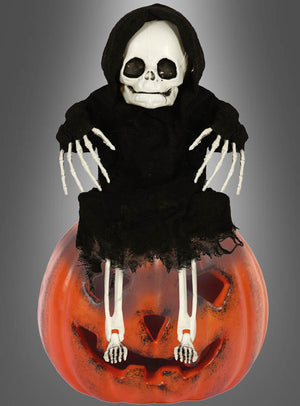 Die „Skelett Garten Deko 40 cm Halloween“ zeigt ein Skelett in einem schwarzen Kapuzenumhang, das auf einem großen, geschnitzten Kürbis mit Jack-o-Lantern-Gesicht sitzt – die ideale, kinderfreundliche Halloween-Party- und Gartendekoration vor einem grauen Farbverlaufshintergrund.