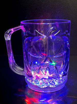 Der große Halloween-Kürbis-Krug LED 700 ml – mit seiner transparenten Form und dem Jack-o’-Lantern-Gesichtsdesign, das von unten durch mehrfarbige LEDs vor einem dunklen Hintergrund strahlend beleuchtet wird – ist ein leuchtender Blickfang, der jeder Halloween-Feier eine gruselig-schöne Atmosphäre verleiht.