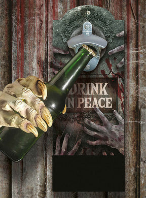 Eine Monsterhand mit Krallen öffnet eine Flasche mit dem „Wand-Flaschenöffner 30 x 12 cm aus Holz“, der über einem Schild mit der Aufschrift „Drink in Peace“ angebracht ist und von Bildern ausstreckender Zombiehände umgeben ist. Dieser einzigartige Flaschenöffner im Halloween-Stil verbindet gruselige Dekoration mit praktischer Funktion und eignet sich somit perfekt für Ihre nächste Themenparty.
