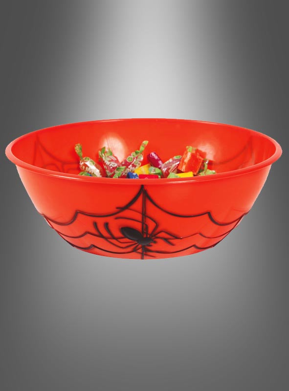 Die Halloween-Schüssel 27 cm mit Spinnenmotiv ist eine rote Kunststoffschüssel mit einem schwarzen Spinnennetz- und Spinnenmotiv, gefüllt mit verschiedenen verpackten Süßigkeiten und perfekt als festliche Halloween-Tischdekoration geeignet, abgebildet vor einem grauen Farbverlaufshintergrund.