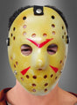 Eine Person, die die gelbe „Horror Hockey“-Maske für Halloween mit roten Markierungen und zahlreichen Belüftungslöchern trägt, blickt nach vorne. Diese furchterregende Halloween-Maske ist ideal für alle, die den klassischen „Hockeymaskenmörder“-Stil lieben.