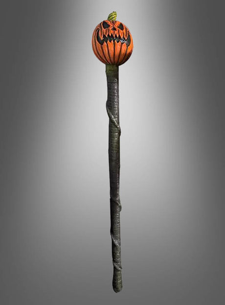 Ein langer, dunkler Stab, dessen Spitze mit einem geschnitzten, bedrohlich wirkenden Kürbiskopf verziert ist: Der „Deluxe Kürbis Stab 136 cm“ ist das perfekte Halloween-Accessoire und wird hier vor einem schlichten grauen Hintergrund mit Farbverlauf gezeigt.