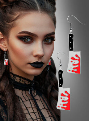 Eine Frau mit dunklem Make-up und geflochtenen Haaren trägt „Fleischmesser-Ohrringe Halloween“ – Ohrringe in Form blutiger Fleischmesser –, die sich perfekt für Horror-Kostüme eignen und vor einem grauen Hintergrund mit Farbverlauf zu sehen sind.