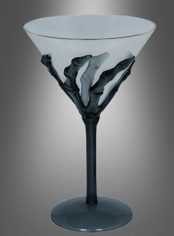 Ein transparentes Cocktailglas „Skeletthand“ (18 cm) mit schwarzem Stiel und einem auffälligen Skeletthand-Motiv, das sich um den Kelch windet, vor einem grau verlaufenden Hintergrund – perfekt als einzigartiger Blickfang für Ihre Halloween-Party oder als auffällige Halloween-Dekoration.