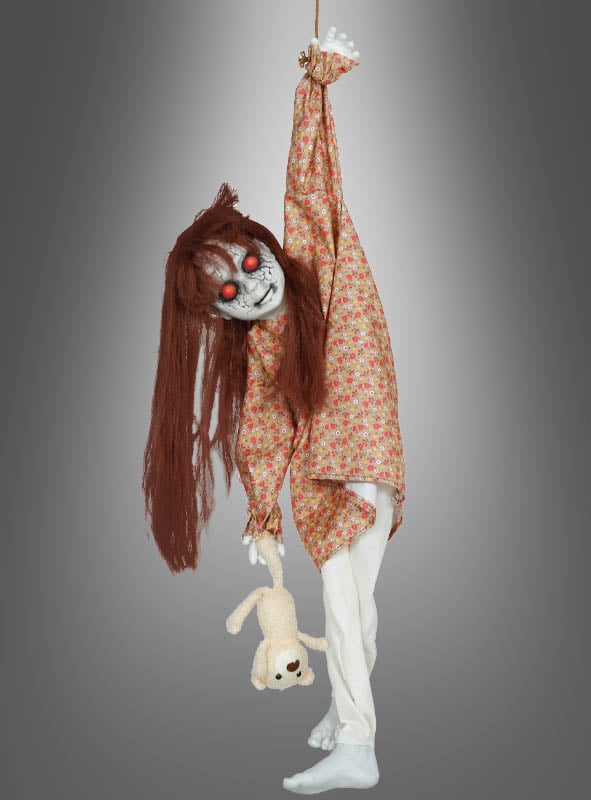 Die „Hängende Horror-Puppe“ (90 cm) hat langes braunes Haar, rote Augen und trägt ein geblümtes Kleid. Sie hängt an einem Arm und hält einen Teddybären fest, vor einem grauen Hintergrund – eine beunruhigende, animierte Halloween-Dekoration, die Ihren Gästen garantiert Gänsehaut bereiten wird.