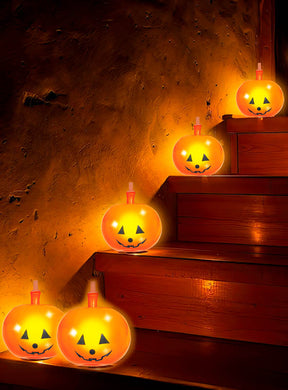 Fünf leuchtende Kürbislaternen mit Kerzen im Inneren stehen auf den Stufen einer Holztreppe vor einer strukturierten Wand und werden durch 5 Kürbis-Ballons mit LED (20 cm) sowie weitere LED-Halloween-Dekorationen ergänzt, die für ein bezauberndes Herbstambiente sorgen.